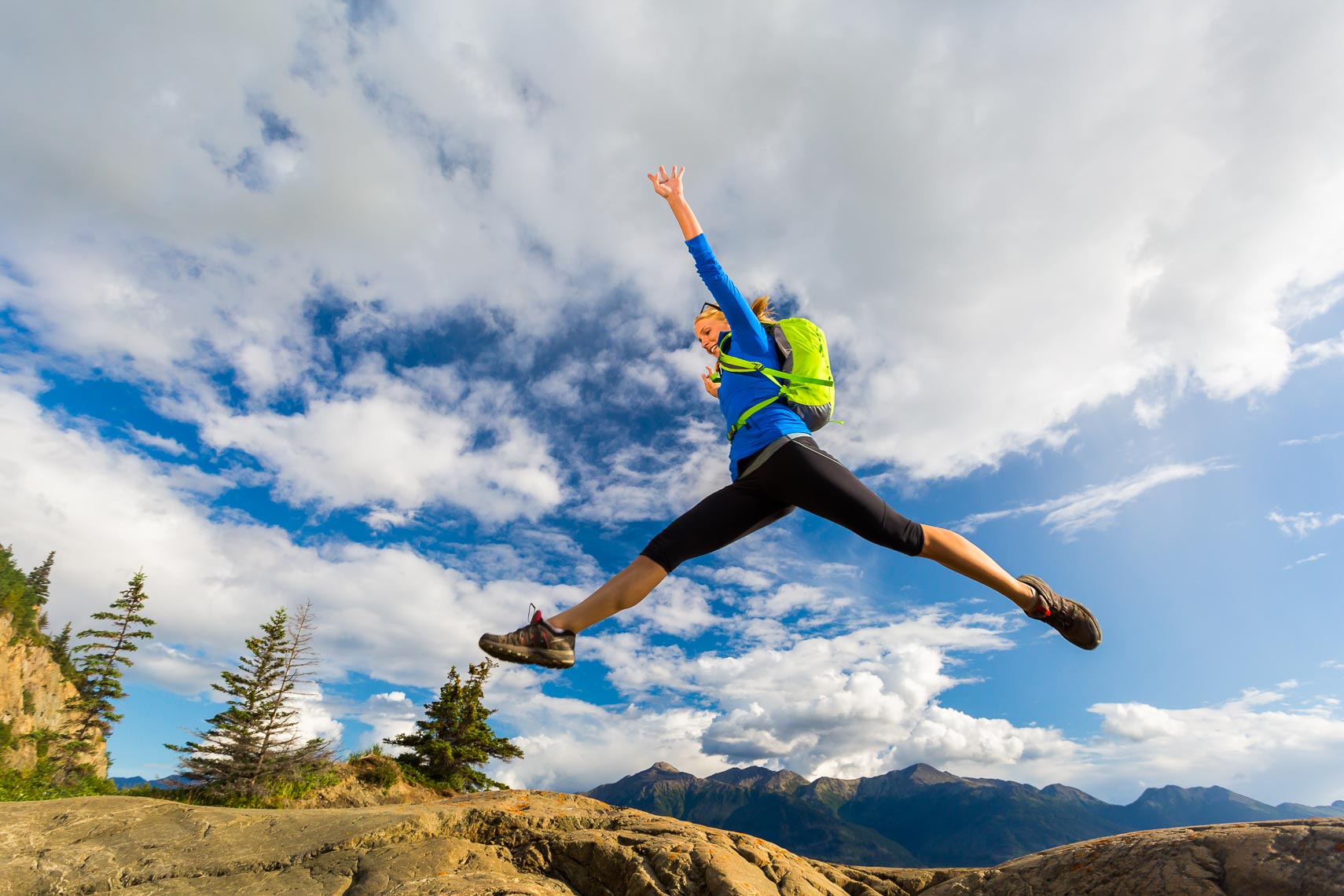 Woman Leaping Rocks Turnagain Arm Alaska | Michael DeYoung